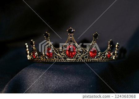 Luxury golden crown with red gemstones and diamonds on dark background. 124368368