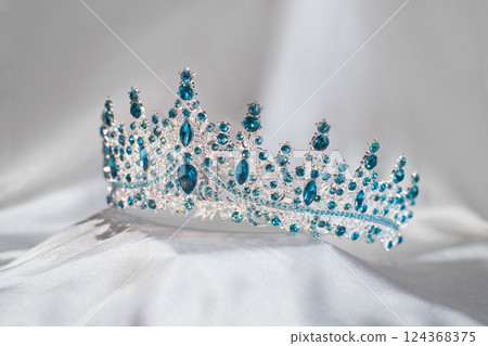 Luxury golden crown with blue topaz gemstones and diamonds 124368375