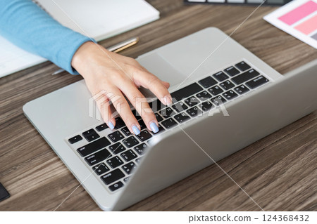 Productivity and Design. A focused professional working on a laptop, showcasing creativity and style. Productivity and Design. A focused professional working on a laptop, showcasing creativity and style. 124368432