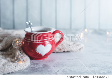 Red cup with white heart and decor details and bokeh copy space on light blurred background. 124368472