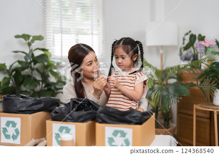 Sustainability and Family Education. A mother and daughter explore recycling together, engaging in fun learning about sustainable practices. Sustainability and Family Education. A mother and daughter explore recycling together, engaging in fun learning about sustainable practices. 124368540