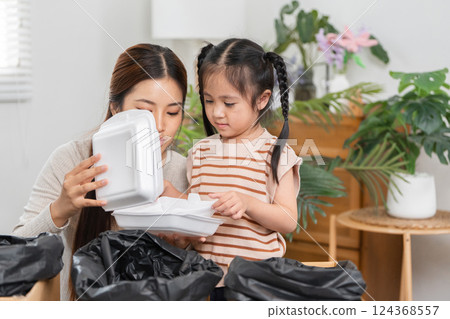 Eco-conscious parenting and Creative Play. A mother introduces her daughter to the importance of waste reduction. 124368557