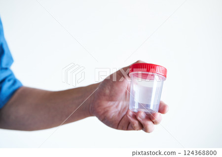 Man holding a sperm collection cup Man holding a sperm collection cup 124368800