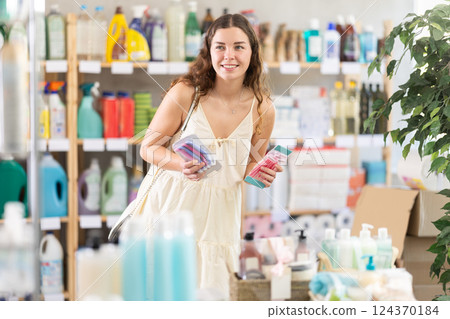 Young woman comparing different packs of razors in supermarket Young woman comparing different packs of razors in supermarket 124370184