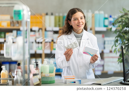 Portrait of female pharmacist working in modern drugstore and offering to buy pills 124370258