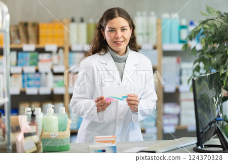 Portrait of female pharmacist working in modern drugstore and offering to buy pills 124370328