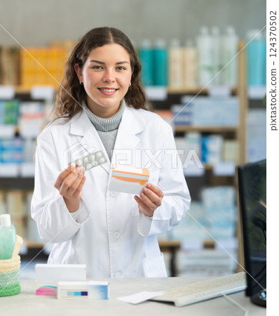 Portrait of female pharmacist working in modern drugstore and offering to buy pills 124370502