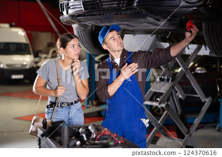 Young guy mechanic posing at car service station 124370616