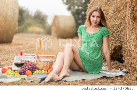 Young woman in dress sitting during picnic 124370633