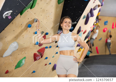 Young woman posing near climbing wall 124370657