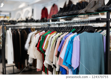 T-shirts and blouses hanging on clothes rack 124370755