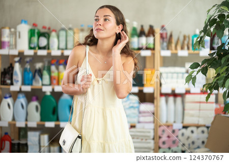 Young woman chooses household chemicals in store Young woman chooses household chemicals in store 124370767