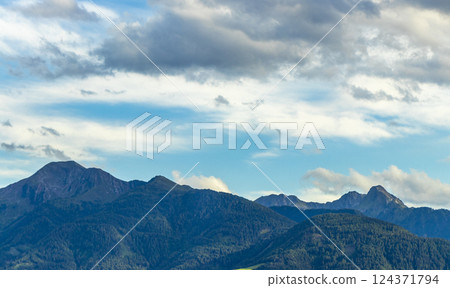 Mountain landscape mountains green fields forest clouds in Tyrol Austria. 124371794
