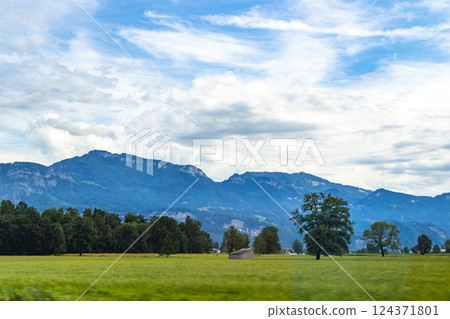 Mountain landscape mountains green fields forest clouds in Vorarlberg Austria. Mountain landscape mountains green fields forest clouds in Vorarlberg Austria. 124371801