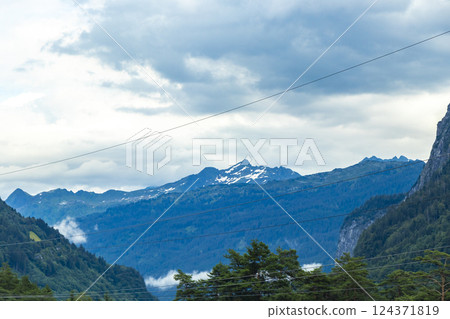 Mountain landscape mountains green fields forest clouds in Vorarlberg Austria. Mountain landscape mountains green fields forest clouds in Vorarlberg Austria. 124371819