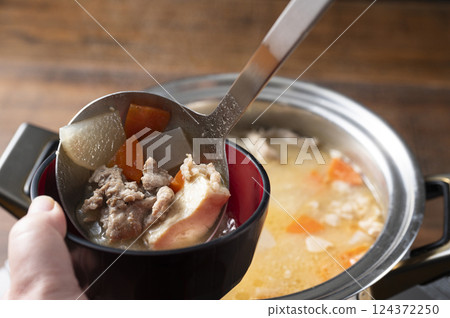 Scooping up the pork soup 124372250