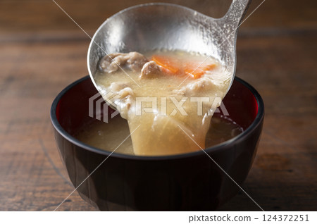 Scooping up the pork soup 124372251