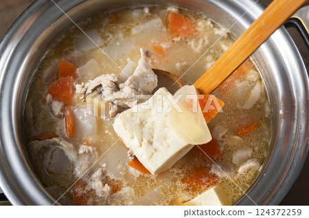 Scooping up the pork soup 124372259
