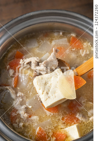 Scooping up the pork soup 124372260
