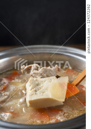 Scooping up the pork soup 124372262