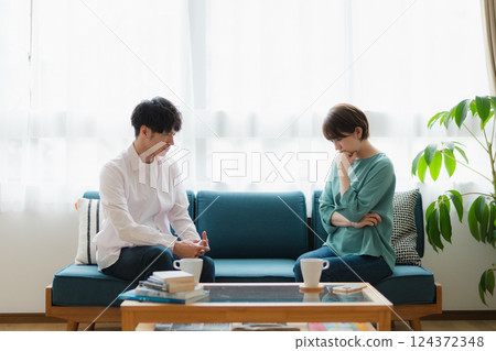 Young couple having a serious discussion - thoughtful expressions in the living room at home 124372348