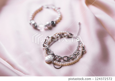 Jewelry on satin fabric with pearl bracelets and wheat elements. Handmade bijouterie And natural aesthetics in fashion 124372572