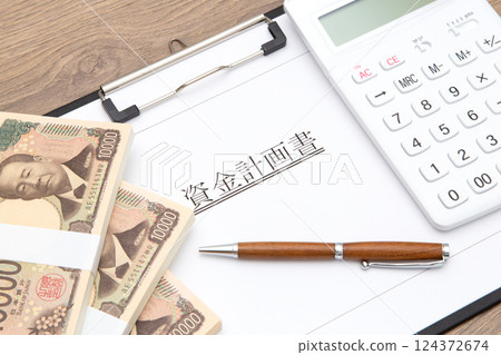 Financial planning image (financial planning document, calculator and stack of bills) 124372674