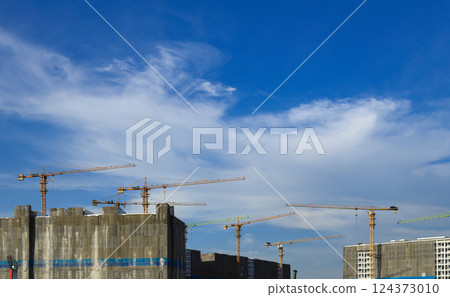 construction tower crane work with construction worker on top of building, used in construction site with blue sky. 124373010