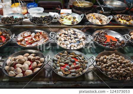 Snails and clams at Asian Street food night market in Vietnam. Vietnamese traditional seafood Snails and clams at Asian Street food night market in Vietnam. Vietnamese traditional seafood 124373053