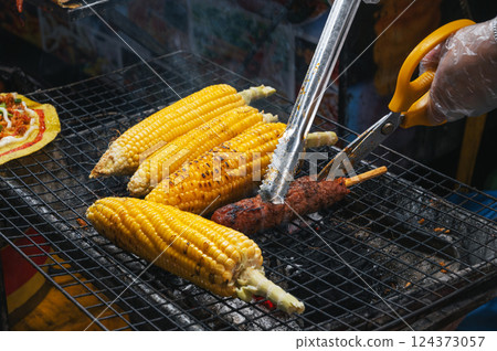grilled corn and meat sausage grilled on fire at Asian street night market in Vietnam in Asia 124373057