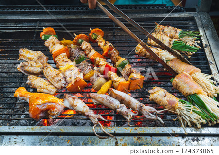Traditional Vietnamese grilled food at Asian street night market in Vietnam in Asia. Meat and seafood are fried on fire Traditional Vietnamese grilled food at Asian street night market in Vietnam in Asia. Meat and seafood are fried on fire 124373065