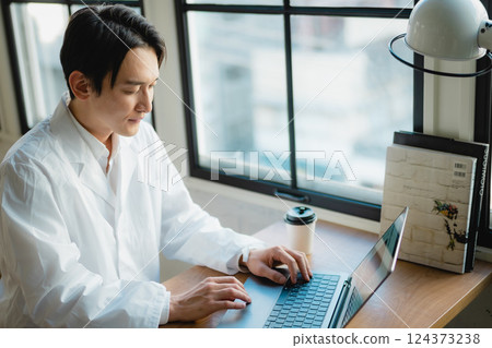 一位年輕的研究人員在安靜的辦公室專注於數據分析 124373238