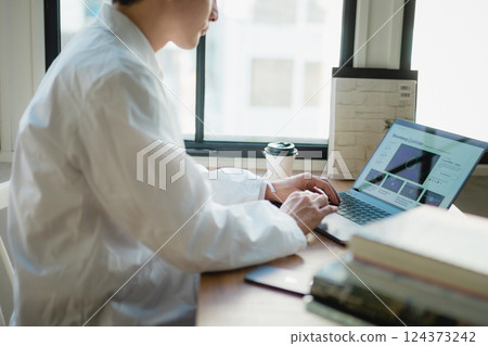 A young researcher concentrating on data analysis in a quiet office A young researcher concentrating on data analysis in a quiet office 124373242