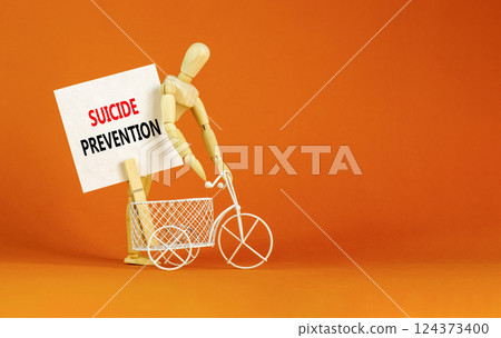 Suicide prevention symbol. Concept words Suicide prevention on beautiful white paper on clothespin. Beautiful orange table orange background. Psychological and suicide prevention concept. Copy space. 124373400