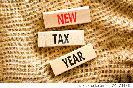 New tax year symbol. Concept words New tax year on beautiful wooden blocks. Beautiful canvas table canvas background. Business new tax year concept. Copy space. New tax year symbol. Concept words New tax year on beautiful wooden blocks. Beautiful canvas table canvas background. Business new tax year concept. Copy space. 124373428