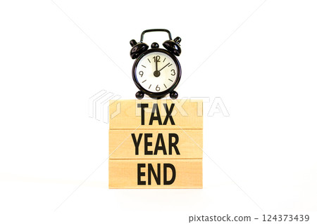 Tax year end symbol. Concept words Tax year end on beautiful wooden blocks. Beautiful white background. Black alarm clock. Business tax year end concept. Copy space. 124373439