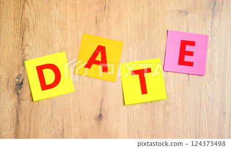Date symbol. Concept word Date on beautiful colored paper. Beautiful wooden table wooden background. Business and date concept. Copy space. 124373498