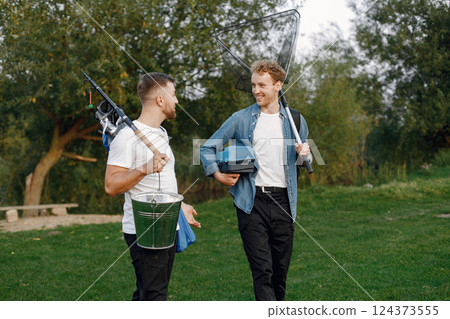 Friends is ready to fishing. Men holding a fishing equipment. One man wearing rose t-shirt and other blue shirt. 124373555