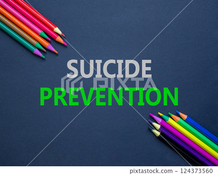 Suicide prevention symbol. Concept words Suicide prevention on beautiful black paper. Colored pencils. Beautiful black table black background. Psychological suicide prevention concept. Copy space Suicide prevention symbol. Concept words Suicide prevention on beautiful black paper. Colored pencils. Beautiful black table black background. Psychological suicide prevention concept. Copy space 124373560