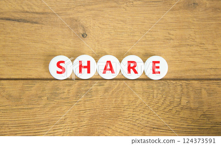 Share symbol. Concept word Share on beautiful white pills circles. Beautiful wooden table wooden background. Business lifestyle share concept. Copy space. 124373591