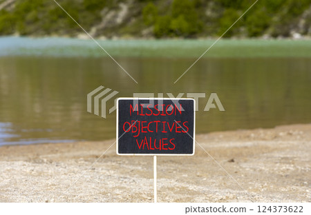 Mission objectives values symbol. Concept words Mission Objectives Values on beautiful black yellow blackboard. Beautiful mountain background. Business mission objectives values concept. Copy space. 124373622