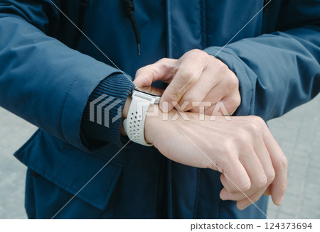 man activates the GPS tracker of his smartwatch man activates the GPS tracker of his smartwatch 124373694