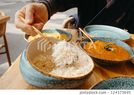 man taking some rice from a bowl man taking some rice from a bowl 124373695