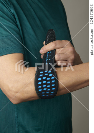 athlete man adjusting his epicondylitis bracelet athlete man adjusting his epicondylitis bracelet 124373698