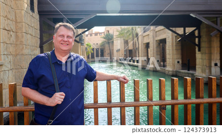 Adult blond man traveling in Venice, standing above water canal 124373913