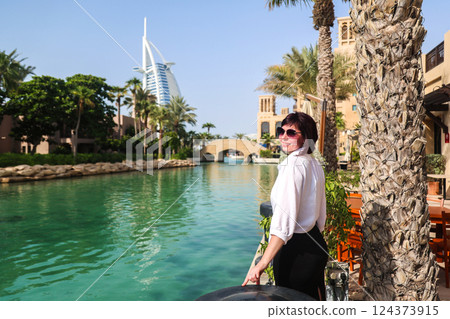 Traveling in Dubai, woman enjoys beautiful view of city architecture Traveling in Dubai, woman enjoys beautiful view of city architecture 124373915