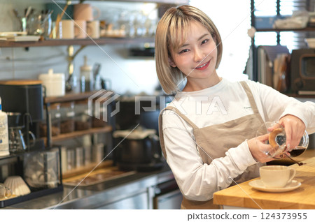 A cafe attendant preparing to make coffee A cafe attendant preparing to make coffee 124373955