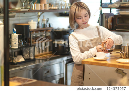 A cafe attendant preparing to make coffee 124373957