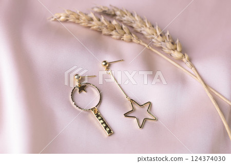 Female Jewelry. Vintage bijouterie jewelry. Beautiful handmade gold earrings on pink silk background. Flat lay, top view copy space and empty space for text 124374030