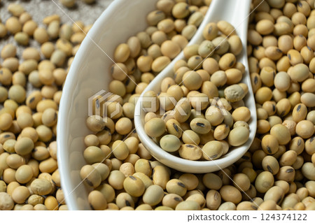 Uncooked soybean seeds in a spoon macro Uncooked soybean seeds in a spoon macro 124374122